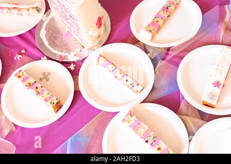 Kleine Scheiben Geburtstagskuchen auf weißem Papier Platten. Stockfoto