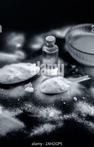 Gesichtsmaske oder Packung Backpulver in eine Glasschüssel auf Holz- Oberfläche zusammen mit Pulver und einige Kokosöl in einem Glasfläschchen. Verwendet für Stockfoto