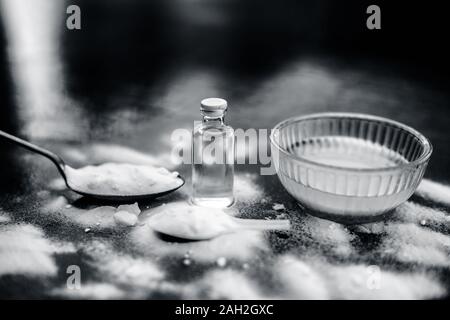 Gesichtsmaske oder Packung Backpulver in eine Glasschüssel auf Holz- Oberfläche zusammen mit Pulver und einige Kokosöl in einem Glasfläschchen. Verwendet für Stockfoto