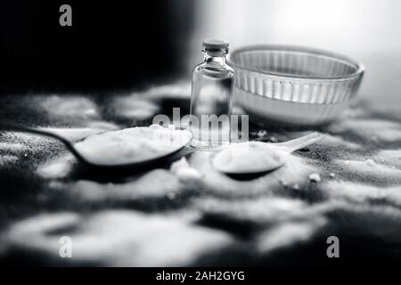 Gesichtsmaske oder Packung Backpulver in eine Glasschüssel auf Holz- Oberfläche zusammen mit Pulver und einige Kokosöl in einem Glasfläschchen. Verwendet für Stockfoto