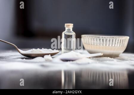 Gesichtsmaske oder Packung Backpulver in eine Glasschüssel auf Holz- Oberfläche zusammen mit Pulver und einige Kokosöl in einem Glasfläschchen. Verwendet für Stockfoto
