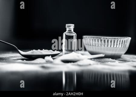 Gesichtsmaske oder Packung Backpulver in eine Glasschüssel auf Holz- Oberfläche zusammen mit Pulver und einige Kokosöl in einem Glasfläschchen. Verwendet für Stockfoto