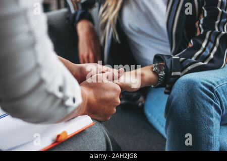 Frau Unterstützung und Hilfe. Frauen halten einander die Hände sitzen in der modernen Loft Büro Stockfoto