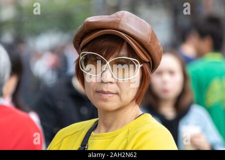 Candid Portrait von Reifen taiwanesischen Frau der Chinesischen Ethnie in der Stadt cool trägt einen Höhepunkt leder Kappe. Stockfoto