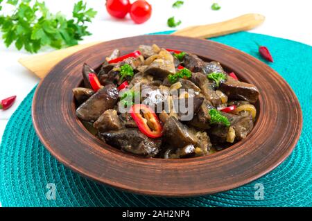 Teile der Türkei gebratene Leber mit Zwiebeln in einem Ton Schüssel auf einem weißen Holz- Hintergrund. Diätmenü. Stockfoto