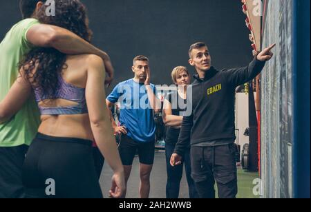 Trainer erklären zu den Athleten in der Turnhalle Stockfoto