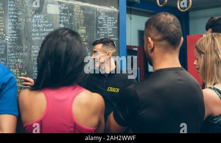 Trainer erklären zu den Athleten in der Turnhalle Stockfoto