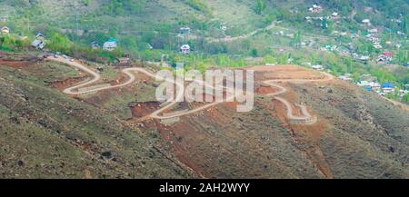 Curvy hügeligen Straße in Astanmarg, Srinagar, Kashmir. Gebogene Straßen von Himalaya Stockfoto