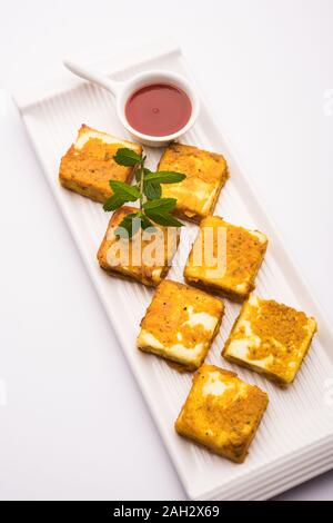 Amritsari Paneer Tikka aus Quark Würfel in einem Teig mit Besan, Chat Masala und Gewürze getaucht und flach in Pfanne gebraten, serviert mit Witz Stockfoto