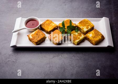 Amritsari Paneer Tikka aus Quark Würfel in einem Teig mit Besan, Chat Masala und Gewürze getaucht und flach in Pfanne gebraten, serviert mit Witz Stockfoto