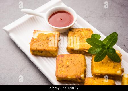 Amritsari Paneer Tikka aus Quark Würfel in einem Teig mit Besan, Chat Masala und Gewürze getaucht und flach in Pfanne gebraten, serviert mit Witz Stockfoto