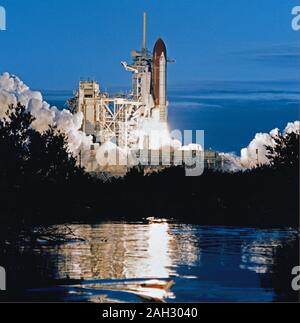 (9 Jan. 1990) - - - das Space Shuttle Columbia, mit einer fünfköpfigen Crew an Bord, hebt ab zum neunten Mal als STS-32 beginnt mit einer 10-tägigen Mission in der Erdumlaufbahn. Verlassen von Launch Pad 39A bei 7:34:59:98 Uhr EST, in diesem horizontalen (7/8 70 mm) Rahmen, Columbia wird gesehen in der Nähe von Marsh Wasser rund 24 Stunden nach zweifelhaften Wetter an der Zurück-zur-Startplatz (RTLS) abgebrochen hatte einen geplanten Start wider. Stockfoto