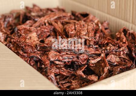 Gesunde natürliche getrocknete Leckereien für Hunde. Luft getrocknet Rindfleisch Lungen in einem Karton. Von der Seite. Selektive konzentrieren. Landschaft Foto Anordnung. Stockfoto