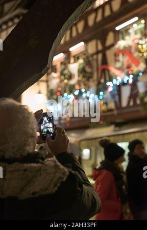 Straßburg, Paris/Frankreich - 14. Dezember, 2019: ältere Bürger, die ein Foto mit Handy der schön dekorierten Fachwerkhäuser in La Stockfoto