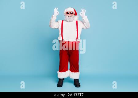 Volle Länge Foto von Fett lustig funky Weihnachten Vater mit großen Bauch abdomen zeigen ok Zeichen empfehlen Winter Shopping Ermäßigungen rote Overalls tragen Stockfoto