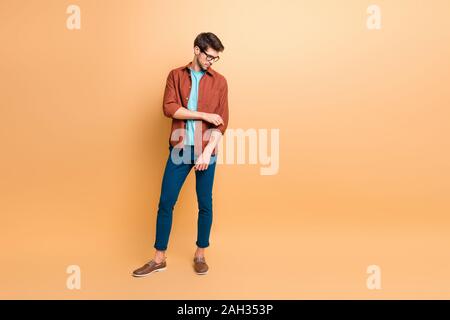 Volle Länge Körper Größe seiner er schöne attraktive modische Ruhe brunette Kerl zur Festsetzung ärmel Vorbereitung Partner Meeting über beige Farbe isoliert Stockfoto