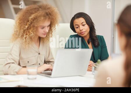 Moderne ethnisch verschieden junge Frauen Coworking Spaces in Office mittlere horizontale Schuß Stockfoto