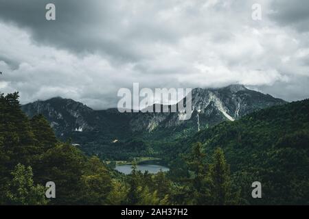 Landschaft in Schwanga in Bayern mit den Königen Schloss und die Wolken am Himmel und die Berge im Hintergrund Stockfoto