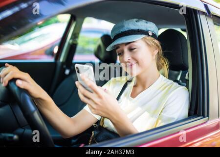 Junge Frau Senden von Nachrichten während der Fahrt Stockfoto