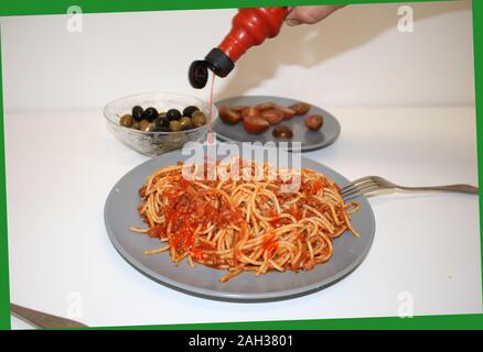 Spaghetti mit Sauce Bolognese gegossen piri piri und Oliven mit Tomaten, Foto im grünen Rahmen Stockfoto
