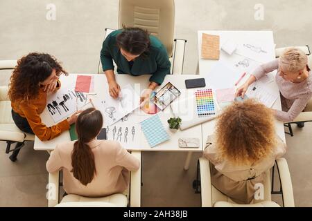 Horizontal von oben geschossen von fünf stilvolle Frauen coworking auf neue Kleider Design Konzept Stockfoto