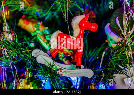 Mini Weihnachten Schaukelpferd hängen vom Baum, in Kings Lynn, Norfolk, Großbritannien, am 23. Dezember 2019. Stockfoto