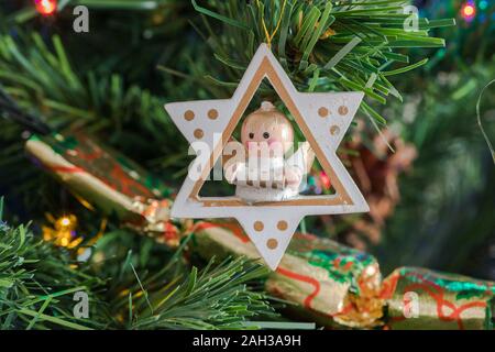 Engel sitzen in einem Stern an den Weihnachtsbaum. In Kings Lynn, Norfolk, Großbritannien, am 23. Dezember 2019. Stockfoto