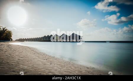 Malediven mit türkisklarem Wasser und viele Palmen und Wolken im Himmel Stockfoto