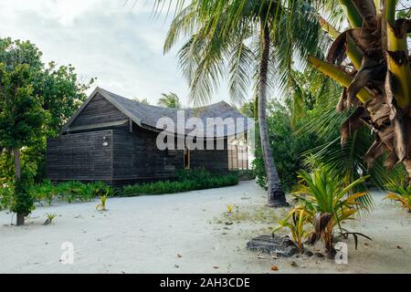 Bungalows und Häuser auf den Malediven mit wunderschönen türkisen Meer und Wolken im Himmel Stockfoto