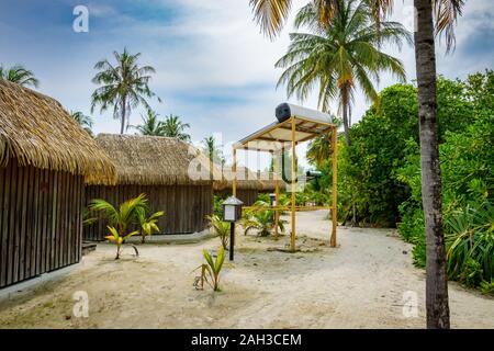 Bungalows und Häuser auf den Malediven mit wunderschönen türkisen Meer und Wolken im Himmel Stockfoto