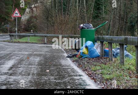 Stadtkyll, Deutschland. 24 Dez, 2019. Illegal entsorgt Müll wird um einen Mülleimer auf einem Parkplatz an der B422 in der Nähe von Stadtkyll. In der Trier, die Gebühren für die Abfallentsorgung wird ab dem 1. Januar 2020 deutlich erhöht werden. Credit: Harald Tittel/dpa/Alamy leben Nachrichten Stockfoto