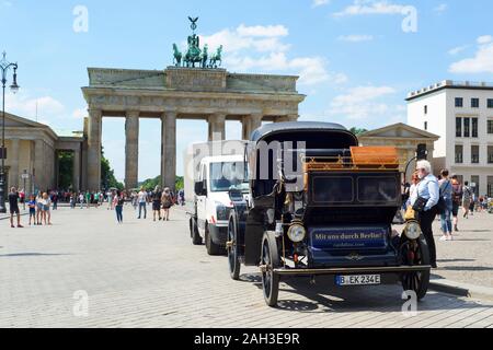 BERLIN, DEUTSCHLAND - 24. MAI 2018: Touristen in der beliebten Brandenburger Tor in Berlin ist eine der wichtigsten Sehenswürdigkeiten in der Stadt und eine elektrische touristische Auto Stockfoto