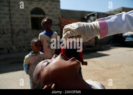 (191224) - Jemen, Dez. 24, 2019 (Xinhua) - die Gesundheit Arbeitnehmer polio Impfstoff für ein Kind während einer Immunisierung Kampagne gegen Kinderlähmung in Sanaa, Jemen, Dez. 24, 2019. Der jemenitischen Behörden am Montag startete eine nationale Kampagne gegen Polio geimpft Targeting über 5,5 Millionen Kinder. Die von der Weltgesundheitsorganisation (WHO) und das Kinderhilfswerk der Vereinten Nationen (UNICEF), die Kampagne wurde gleichzeitig in der jemenitischen Hauptstadt Sanaa und anderen Provinzen des Landes eingeweiht unterstützt. Die dreitägige Impfung Prozess ging von Haus zu Haus Kinder unter fünf Jahren zu immunisieren. (Foto b Stockfoto