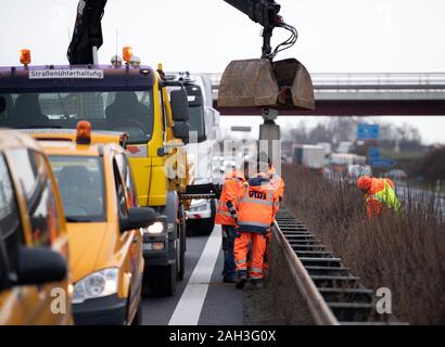 Rangsdorf, Deutschland. 16 Dez, 2019. Arbeitnehmer in orange Kleidung arbeiten auf der begrünten Mittelstreifen der Autobahn A13. Credit: Soeren Stache/dpa-Zentralbild/dpa/Alamy leben Nachrichten Stockfoto