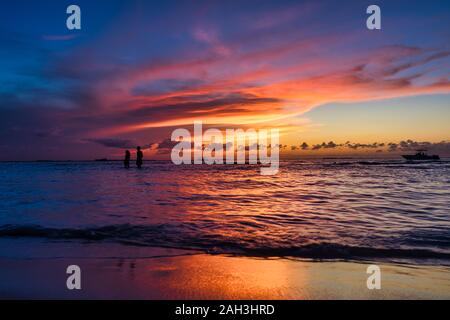 Ein junges Paar spaziergänge bei Ebbe auf einer tropischen Insel Holbox Mexiko. Unglaubliche Sonnenuntergang am Strand. Himmel mit unglaublichen Farben sun Karibik Stockfoto