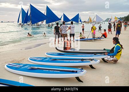 Der Provinz Aklan Boracay, Philippinen - 6. Januar 2018: Sunset Landschaft am weißen Strand mit Paddle Boards und Segeln Boote warten auf Touristen Stockfoto