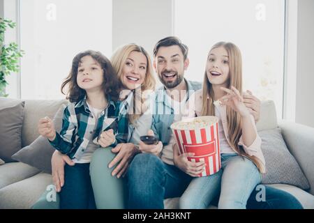 Foto von großen Familie vier Mitglieder durch Fernsehen Show aufgeregt Couch sitzen Essen salziges Popcorn Stockfoto