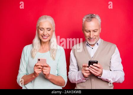 Nahaufnahme Foto schön sie ihr, daß er ihn im Alter von weißem Haar Kerl lady Partner halten Hände arme Telefone texting Kinder moderne Eltern Pullover tragen Stockfoto