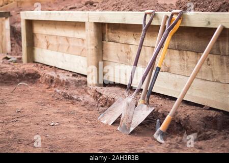 Landschaftsbau arbeiten Werkzeuge und Stützmauer Stockfoto