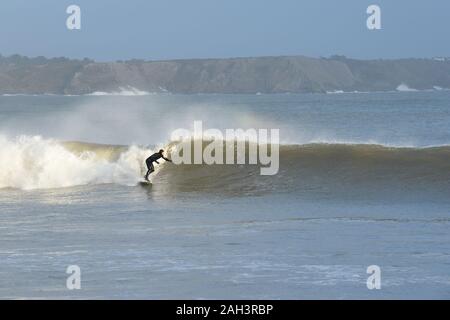 Surfen an Oxwich Bay auf einen perfekten Strand brechen ein Surfer für die schnelle Wand vor ihm Stockfoto