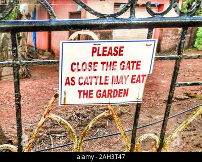 Agonda, Indien - 13. Oktober 2013: Ein Schild an einem Tor zeigt den Besuchern an, es als Schutz vor Kühen zu schließen, wie es in Agonda, Canacona, South Goa, Indien zu sehen ist. Stockfoto