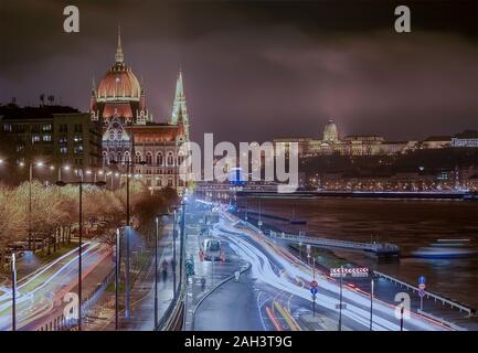 Ungarisches Parlament mit Ampel, die Budaer Burg und Széchenyi Kettenbrücke. Bewölkt Abend erstaunlich leuchtet. Stockfoto