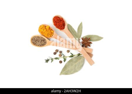 Holzlöffel mit Kümmel, Paprika und Kurkuma Pulver auf weißem Hintergrund Stockfoto