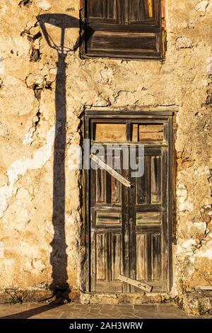 Lampost Schatten durch ein verfallenes Holztür in das Dorf La Quinta, Adeje, Teneriffa, Kanarische Inseln, Spanien, Stockfoto