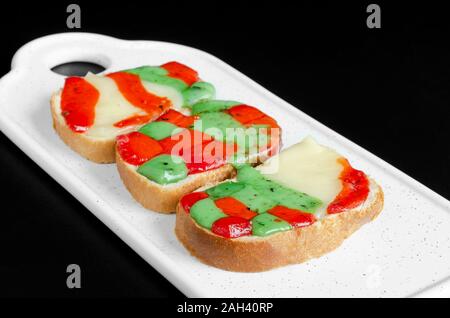 Warme Sandwiches mit geschmolzenem Käse auf schwarzem Hintergrund Stockfoto