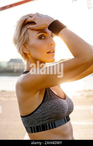 Portrait von blonde Sportlerin, Hände in Haar Stockfoto