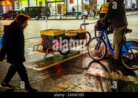 Ein Fahrrad Anlieferung Person beladen mit Amazon frische Lebensmittel wartet der Eighth Avenue in Chelsea in New York am Dienstag, 17. Dezember 2019 zu überqueren. (© Richard B. Levine) Stockfoto