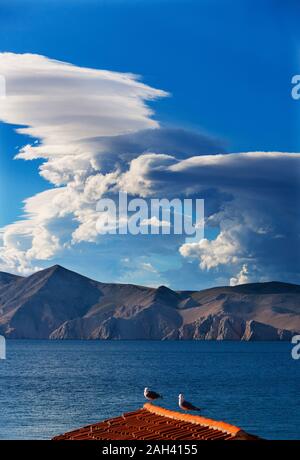 Kroatien, Kvarner Bucht, Baska, Wolken und der Küste, die Tauben auf dem Dach Stockfoto