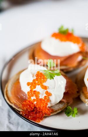 Blinis mit Sauerrahm, geräuchertem Lachs und Fischrogen Stockfoto