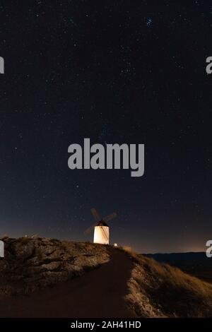 Spanien, Provinz von Toledo, Consuegra, Sternenhimmel über alte Windmühle auf dem Hügel bei Nacht Stockfoto